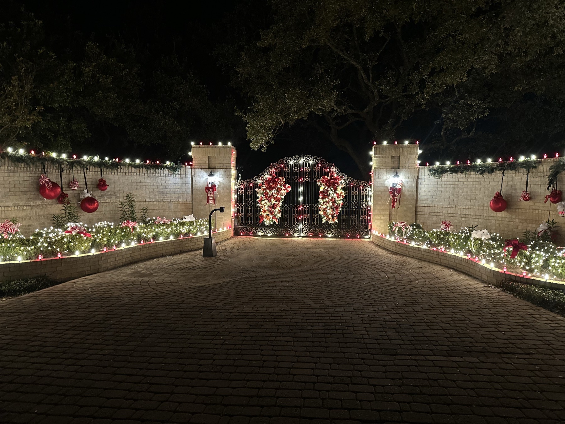 Gated driveway with Christmas lights and garland